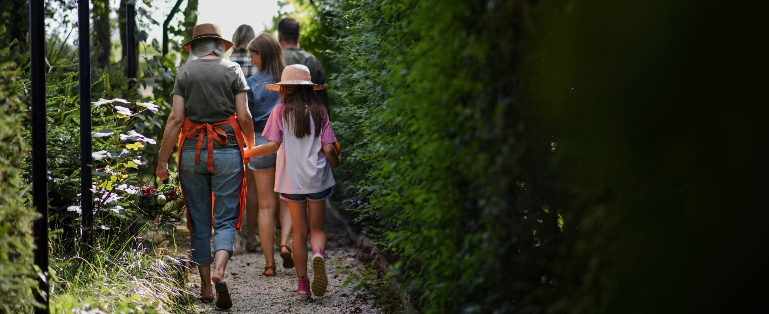 A family of three generations walking down a garden path